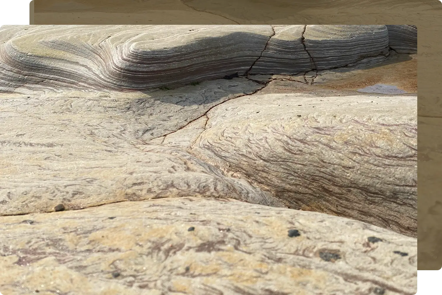 Close-up of weathered, layered rock formations with curving lines and earthy tones. With crack lines symbolising something is misaligned within the path